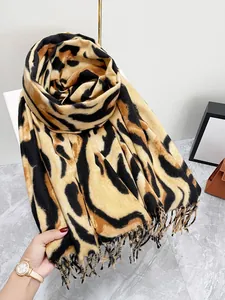 Dettaglio dello scialle leopardato con texture effetto cashmere e nappe eleganti