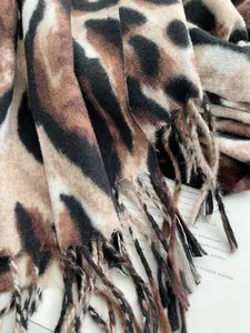 Dettaglio di sciarpa leopardata spessa effetto cashmere con frange e trama morbida