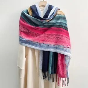 Sciarpa artistica con strisce sfumate e nappe drappeggiata sopra un cappotto chic