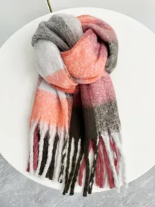 Dettaglio di sciarpa a quadri arcobaleno con nappe spesse e morbida trama in mohair