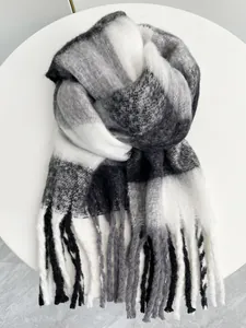 Dettaglio di una sciarpa a quadri bianca e nera in mohair con frange morbide