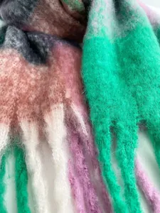 Dettaglio macro di sciarpa colorata in mohair con frange spesse e trama morbida