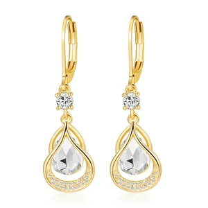Macro detail of gold-plated teardrop earrings with sparkling pear-cut crystals