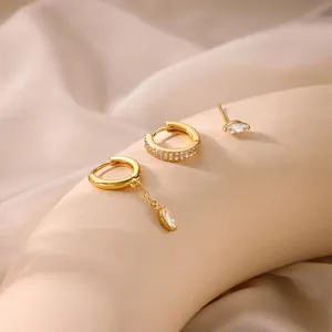 Detailed view of three-piece gold brass earring set with marquise and baguette zircons