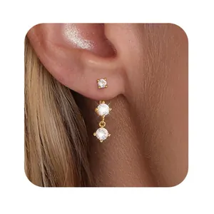 Close-up of triple zircon drop earrings in gold plating worn on woman's ear