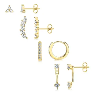 Ensemble de boucles d'oreilles fleurs dorées avec zircons étincelants sur fond blanc