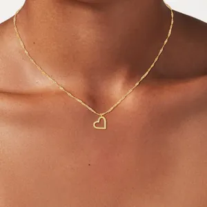 Elegant gold-tone twist heart pendant necklace shown on female model collarbone