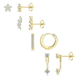 Ensemble de boucles d'oreilles fleurs dorées avec zircons sur fond blanc pur