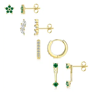 Détails de boucles d'oreilles fleuries dorées serties de zircons verts émeraude et clairs