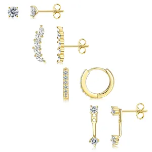 Détails de quatre boucles d'oreilles en zircon doré incluant créoles et clous sur blanc
