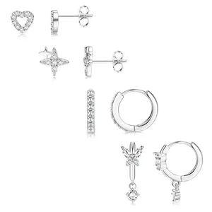 Détails macro de quatre paires de boucles d'oreilles argentées serties de zircons cubiques