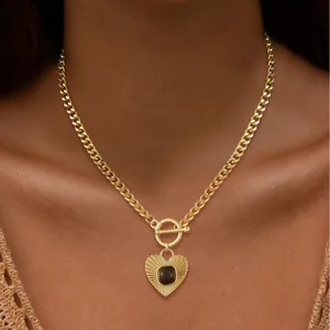 Golden heart pendant necklace with Cuban chain and front OT toggle clasp shown on neck