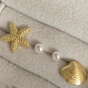 Elegantes Set aus Ohrsteckern mit goldenem Seestern, Muschel und weißen Perlen