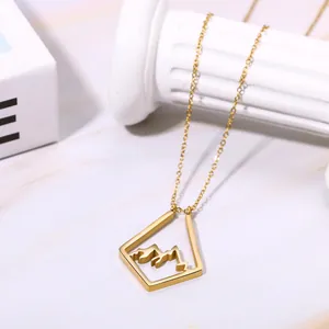 Gold plated brass necklace with a minimalist hollow mountain pendant on marble background