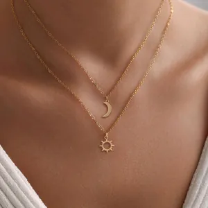 Gold-plated layered necklace set featuring dainty sun and moon pendants on a female model