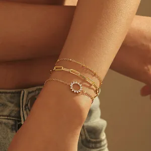 Ensemble de trois bracelets dorés avec zircons et chaînes délicates superposées