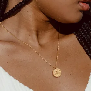 Collier en laiton doré avec pendentif pièce en relief méduse porté par un mannequin