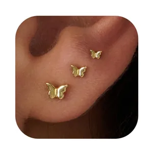 Three-piece gold plated brass butterfly stud earrings set worn on ear for minimalist look