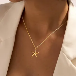 Collier élégant avec pendentif étoile de mer dorée porté par un mannequin chic