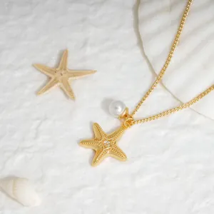 Collier étoile de mer doré avec zircon et perle sur fond de coquillage blanc