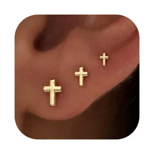 Three-piece gold plated brass cross stud earrings set in graduated sizes on ear