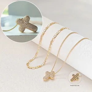 Gold hollow cross pendant necklace set with pavé cubic zirconia on textured stone