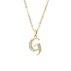 Macro detail of gold plated letter G pendant necklace with sparkling zircon inlay