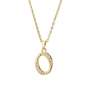 Detailed close-up of golden letter O pendant with zircon stones on a brass chain