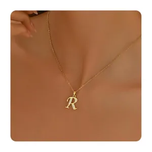 Detail of gold-plated letter R pendant necklace with zircon stones on thin chain