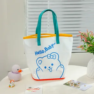 Detail of PVC jelly tote bag with cartoon bear print and blue handles for beach travel