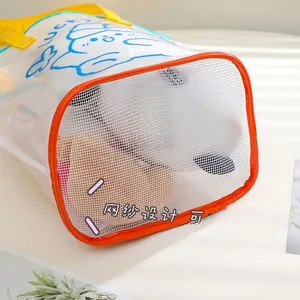 Detail of transparent PVC beach bag with breathable mesh bottom for drainage and lucky print