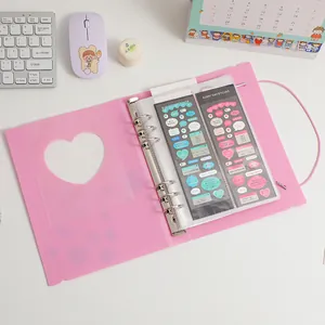 Roze A5 fotoalbum met hartuitsnijding, 6-ringband en elastische sluiting op bureau