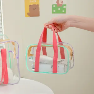 Transparent PVC tote bag with pink straps and green trim for beach or makeup storage