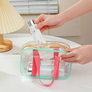 Detail of transparent PVC tote bag with mint green edges and pink handles for toiletries