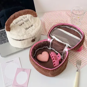 Detalle del neceser de peluche con compartimento de malla y forro de lunares interno
