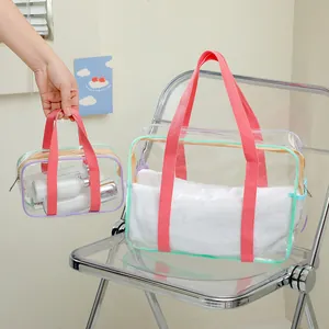 Close-up of waterproof transparent PVC storage bags with pink handles and colored trim