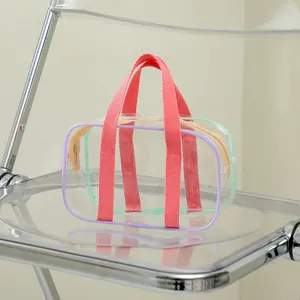 Detail of pink fabric handles and purple PVC edging on the clear jelly tote bag