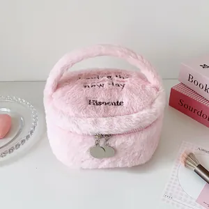 Detalle de neceser rosa de felpa con bordado y cremallera metálica de doble sentido