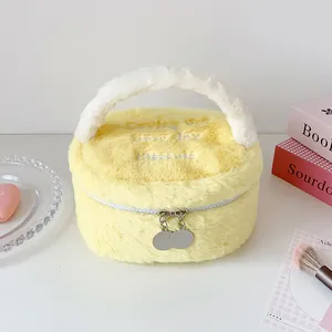 Detalle de bolsa de maquillaje de felpa amarilla con bordado blanco y doble cremallera