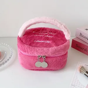 Detalle del neceser de felpa rosa con textura suave y bordado de letras elegantes