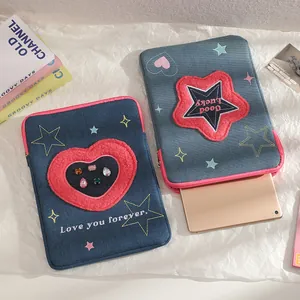 Dettaglio custodia tablet in denim con toppe in peluche a cuore e stella ricamate