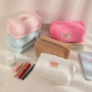 Close-up of colorful plush cosmetic bags with soft faux fur texture and zipper closure