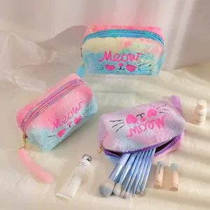 Detail of plush cat makeup bags with Meow embroidery and fuzzy tail zipper pullers
