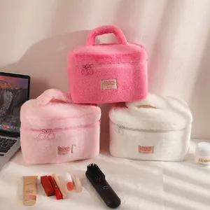 Détail de trousses à maquillage en peluche avec zips en anneau et poignées