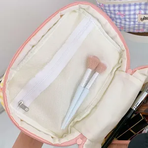 Détail macro de la trousse de maquillage à carreaux avec poche zippée et rangement pinceaux