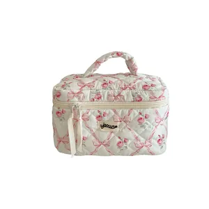 Trousse de maquillage matelassée avec fleurs, nœuds roses et poignée pour voyage