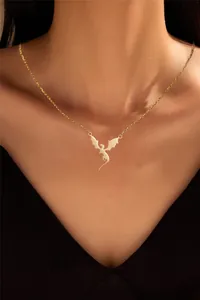Detailed close-up of a golden dragon pendant necklace worn on a neck with fine chain