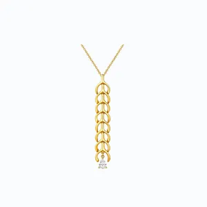 Close-up of gold-plated layered necklace featuring leaf pendants and a pear-cut zircon
