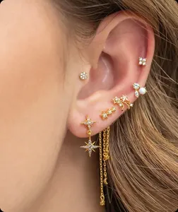 Detailed close-up of gold-plated tassel earrings with zircon stars and pearl accents