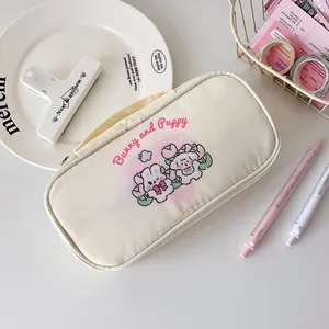 Macro detail of the creamy white canvas pencil case with cute puppy and bunny illustrations